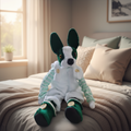 Plush toy dog in green and white outfit on a white background